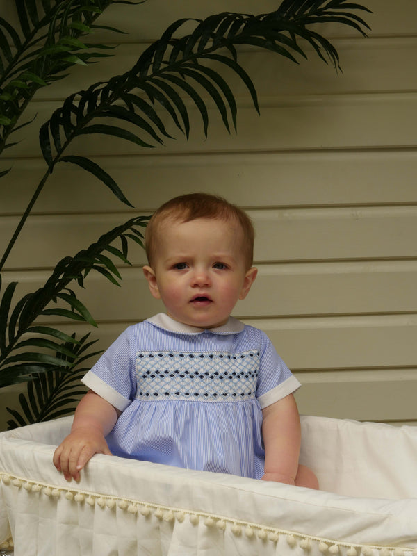 Baby boy wearing blue striped smocked babysuit