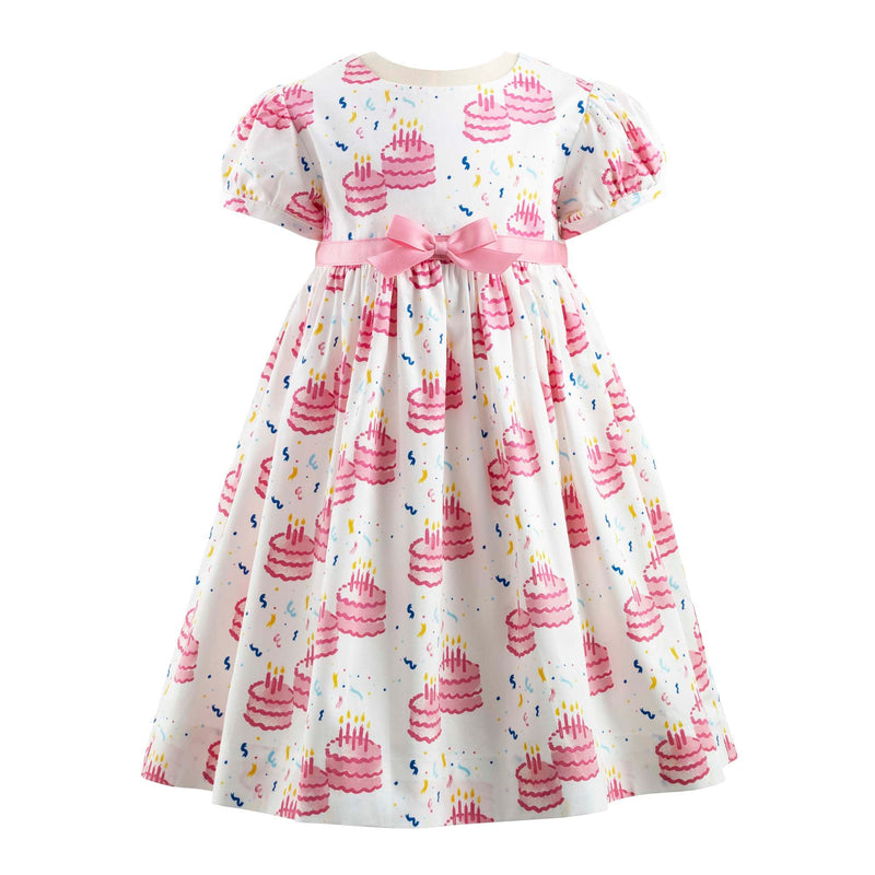 Baby girls party dress with pink birthday cake print, puff sleeves and pink ribbon and bow at waist.