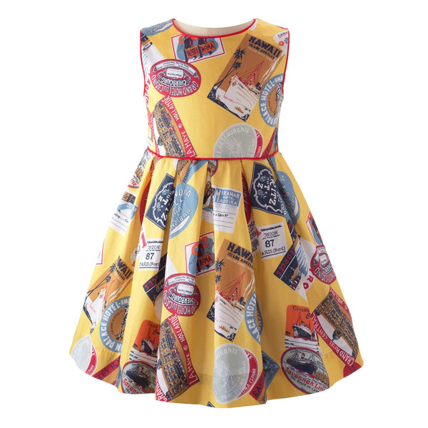 Girls sleeveless pleated dress with travel stamp print on yellow base and red piping on bodice.