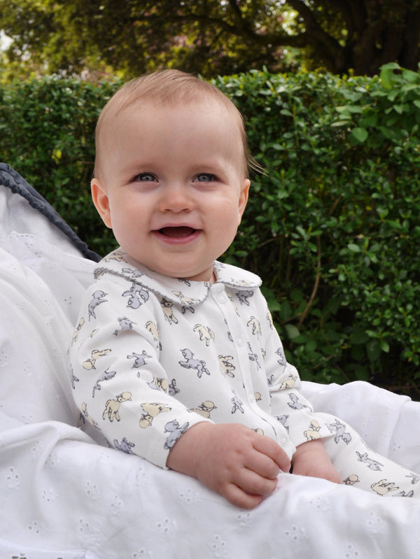 Baby wearing soft cotton ivory babygro with grey and yellow lamb print