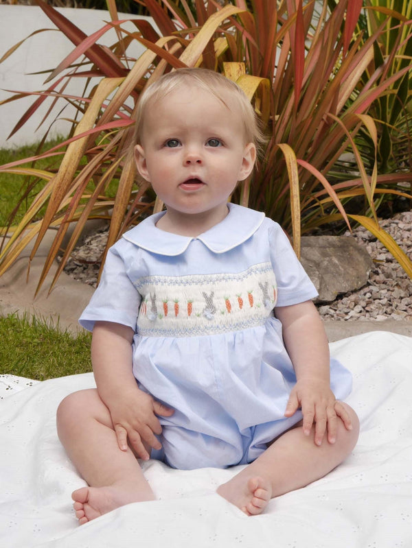 Baby wearing blue and ivory striped babysuit with hand-smocked bunnies across the chest.