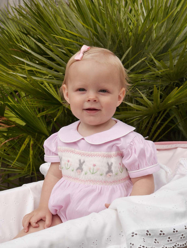 Baby girl wearing pink bunny smocked babysuit and matching pink haibow.