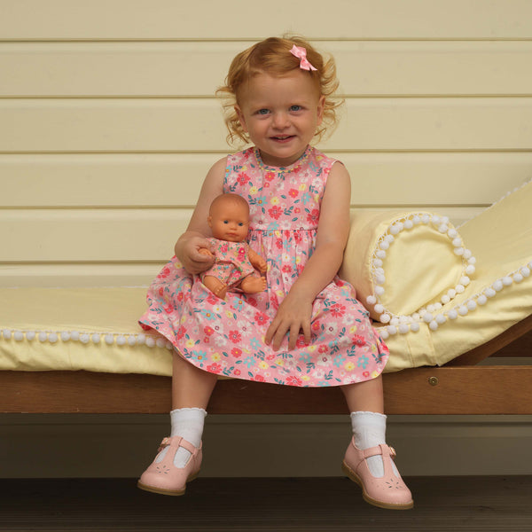 Baby girl wearing pink flower fields dress styled with ivory ankle socks, pink slippers and hairbow
