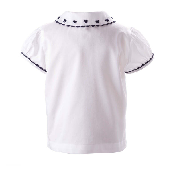 Baby white blouse with navy bow embroidered peter pan collar, trimmed with frills and navy pipping.