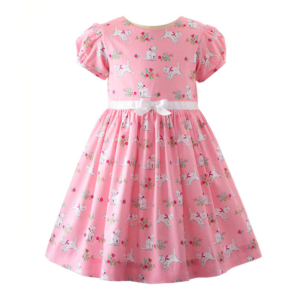 Girls party dress with kitten print on pink base, puff sleeves and ivory ribbon and bow at waist.
