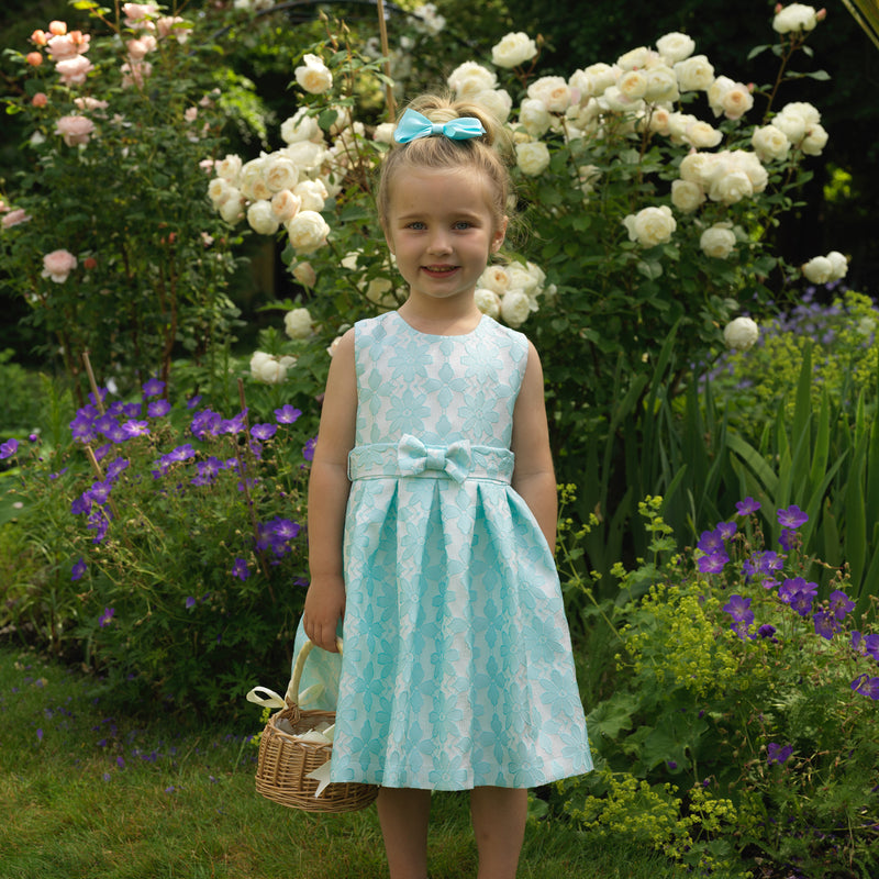 Girl in aqua damask party dress and matching hairbow.