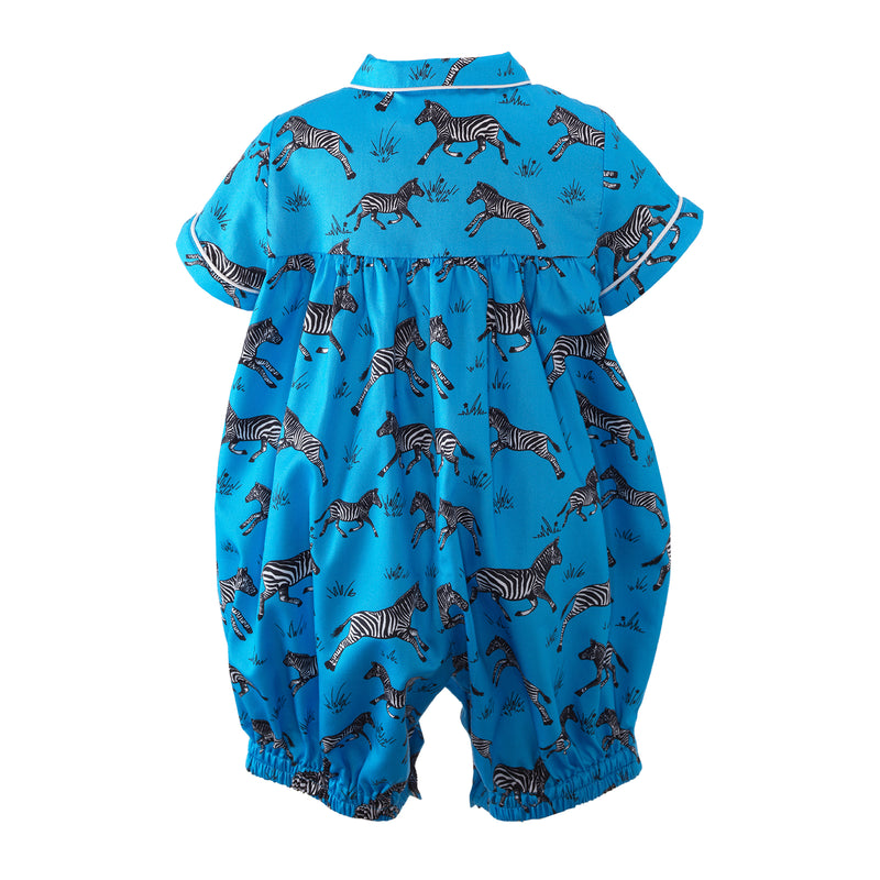 Baby boys cotton babysuit with galloping zebra print on deep blue background.