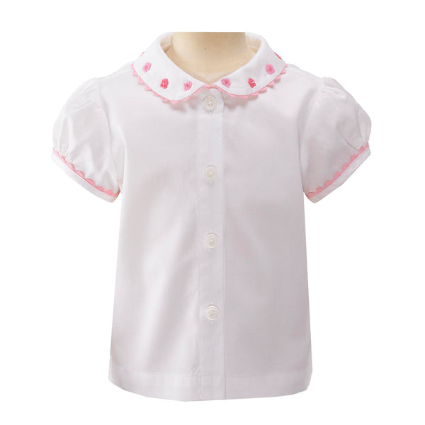 Baby white blouse with pink daisy embroidered peter pan collar, trimmed with frills and pink piping.