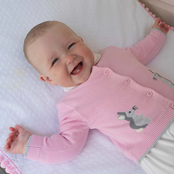 Baby girl wearing pink bunny intarsia cardigan styled with white bloomers.
