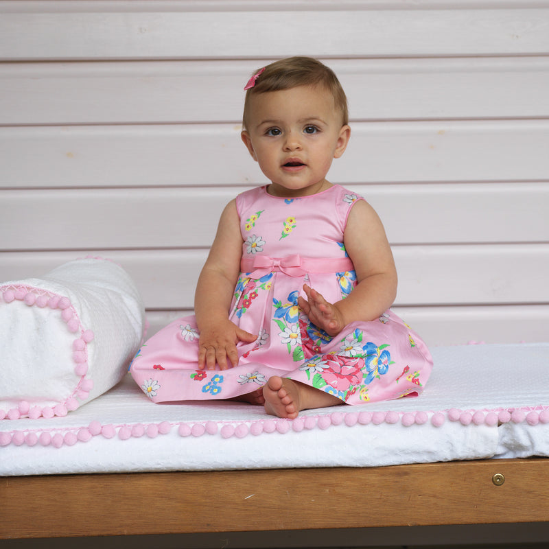 Baby girl wearing Rose Bouquet Dress with matching bloomers and pink hairbow