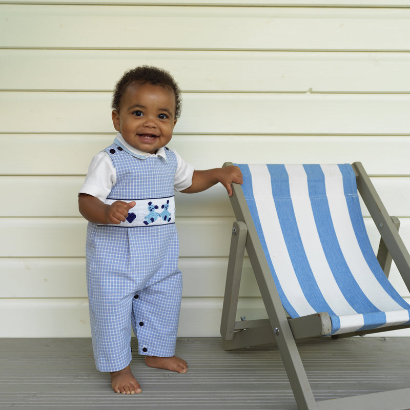 Baby boy wearing heart teddy smocked dungarees styled with Blue Short Sleeved Piped Bodysuit.