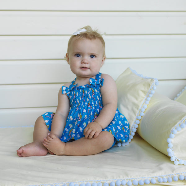 Baby girl wearing blue mermaid print top and shorts set with matching hairbows.