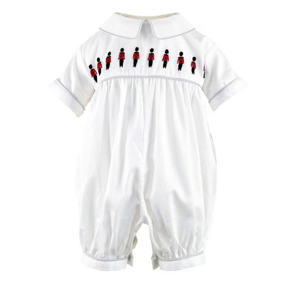 Ivory babysuit with soldier embroidered motif on chest and grey piping at collar and cuffs.