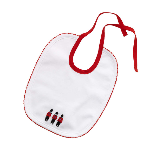 Ivory bib with soldier embroidered motif and red woven lining and strap