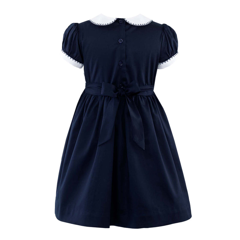 Girls navy smocked dress with ivory peter pan collar and short puff sleeves.