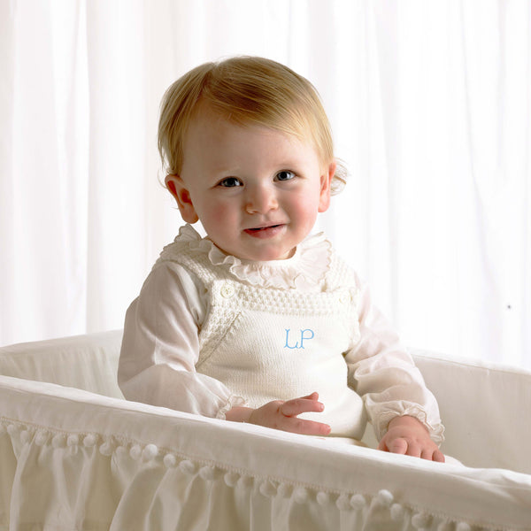 Baby girl wearing ivory moss stitch strap romper styled with ivory trim frill collar body.