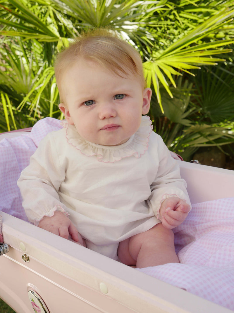 Baby in pink trim frill collar blouse with jersey body underneath and long sleeves.