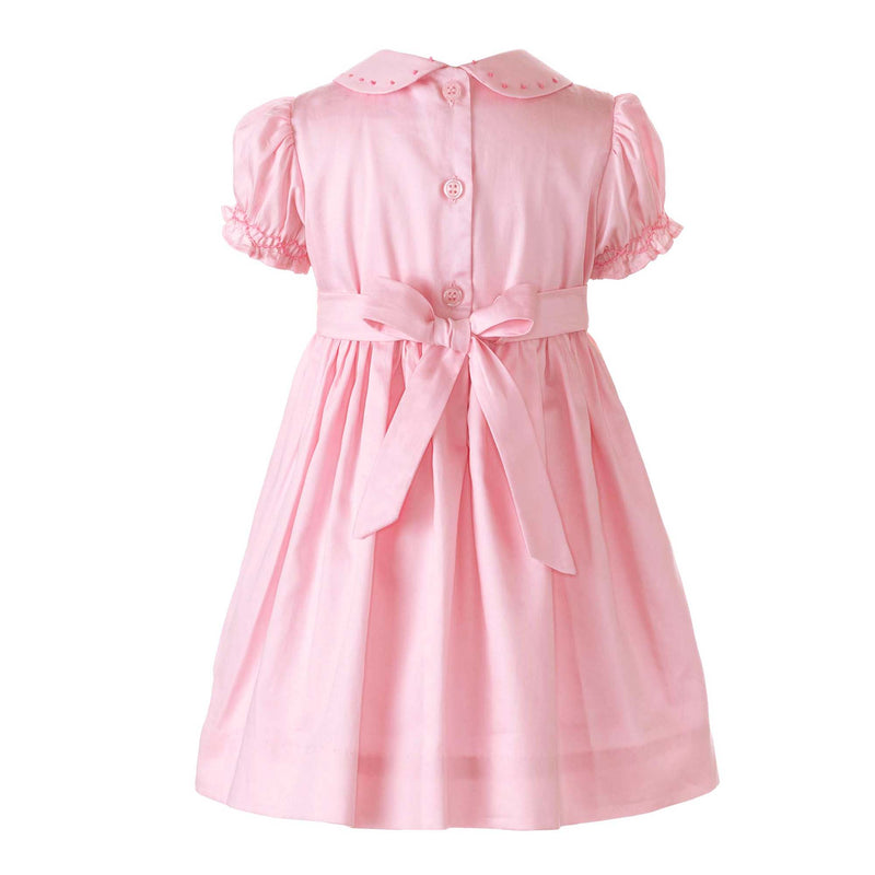 Baby girls pink dress with smocked bodice, embroidered bows, peter pan collar and gathered skirt.