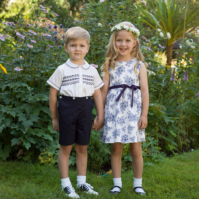Boy wearing navy smocked set and girl wearing matching navy floral toile dress