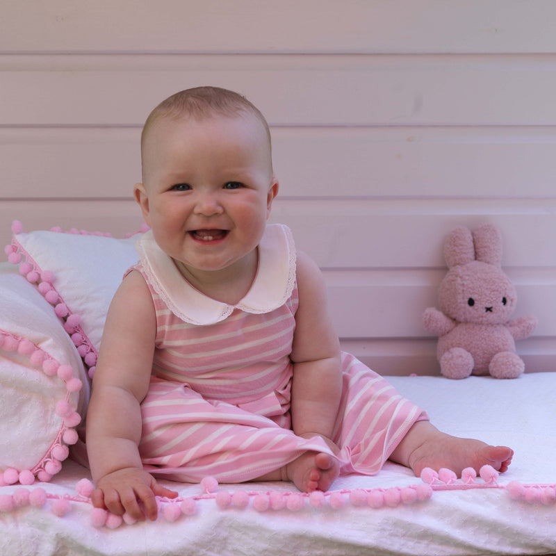 Baby girl wearing pink sleeveless breton stripe jersey dress.