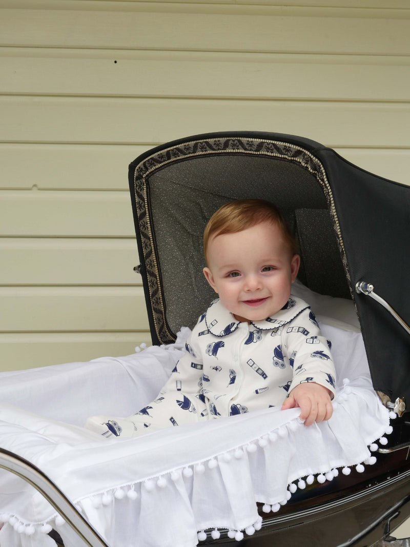 Baby boy wearing pram print babygro.